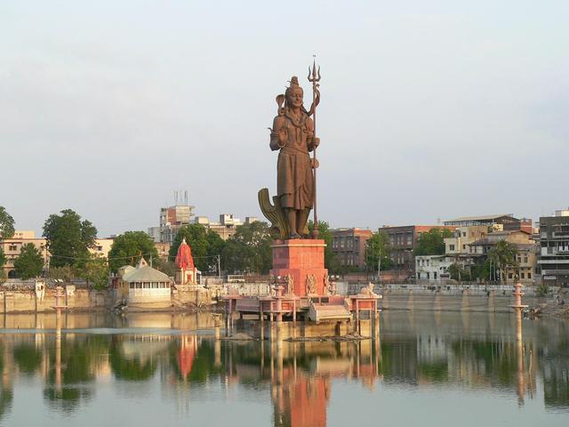 A statue of Shiva watches over Sursagar Lake