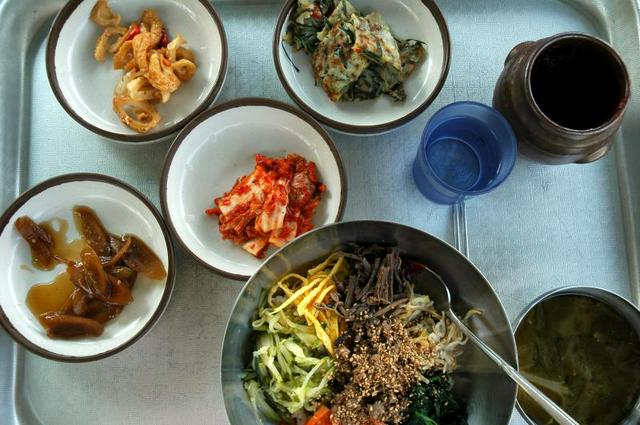 Example of a Korean meal: bibimbap with (from left) pickles, eomuk jorim sauteed fishcake, kimchi, pajeon pancake, a pot of gochujang and doenjang soup