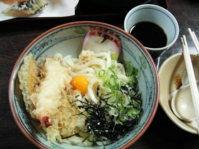 Bukkake udon, with tempura shrimp and a cup of sauce waiting to be poured on