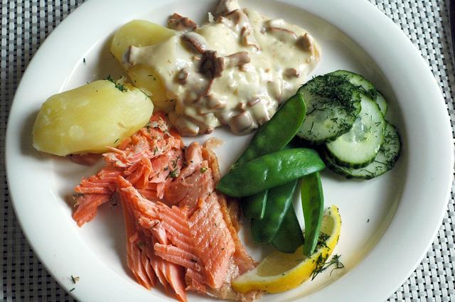 A typical Finnish meal. Clockwise from bottom: warm smoked salmon, boiled potatoes, cream sauce with chantarelles, lightly pickled cucumbers with dill
