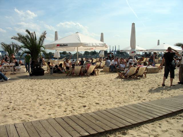 The Hamburg City Beach Club, complete with palm trees, deck chairs, umbrellas and a view of the port and huge container ships