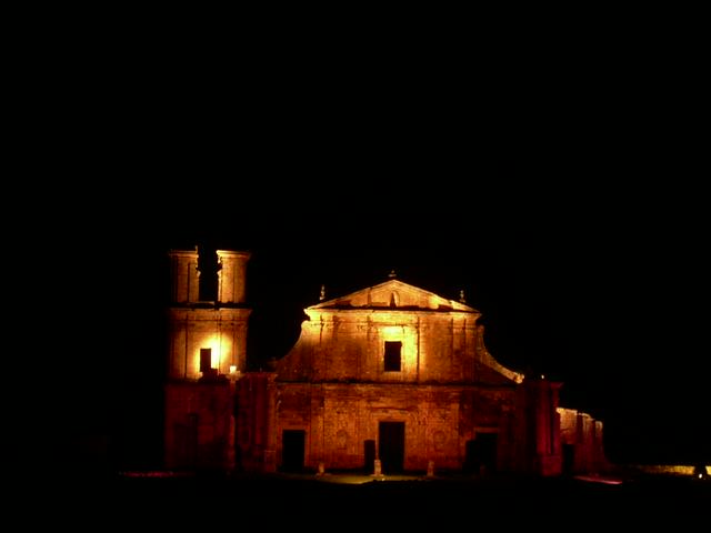 The ruins illuminated at night.