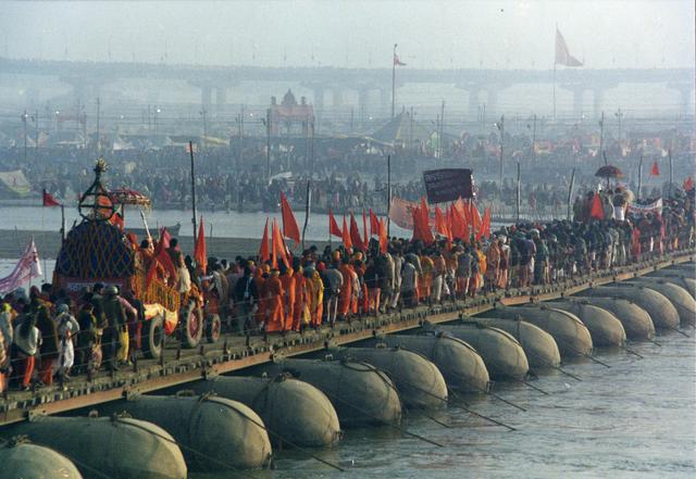 Hindu pilgrims cross the river Ganges during the 2001 Kumbh fair.