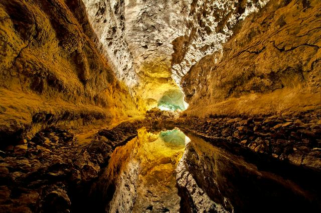 Cueva de los Verdes, with the ceiling reflected in the water on the floor of the lava tube