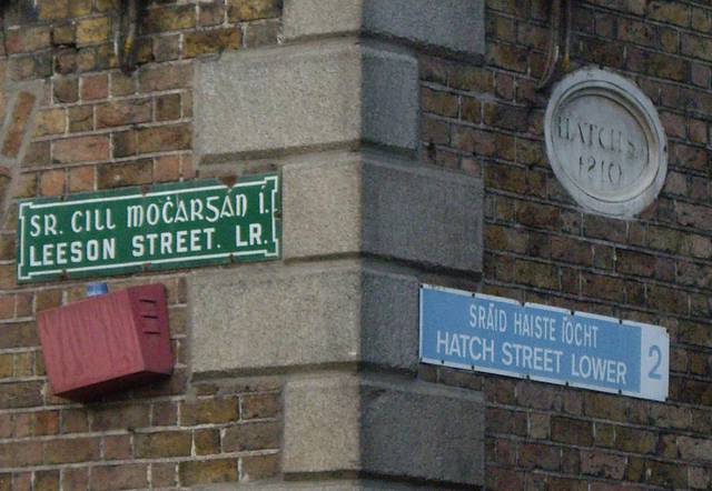 The green Leeson St nameplate pre-dates inclusion of postal districts; the newer blue Hatch St nameplate indicates the district is Dublin 2