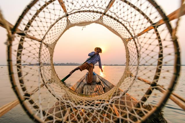 A fisherman on Inle lake, rowing the boat with his leg