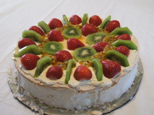 Pavlova topped with strawberry, kiwifruit and passionfruit