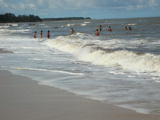 Tourists enjoying in the waves on a sunny day on Kihim Beach