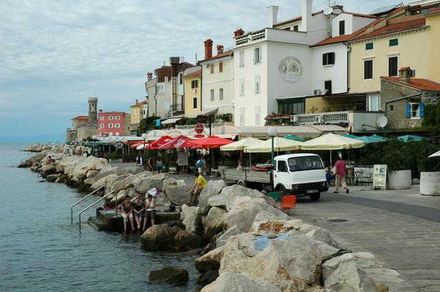 Piran's coast with colorful buildings, swimming piers and restaurants