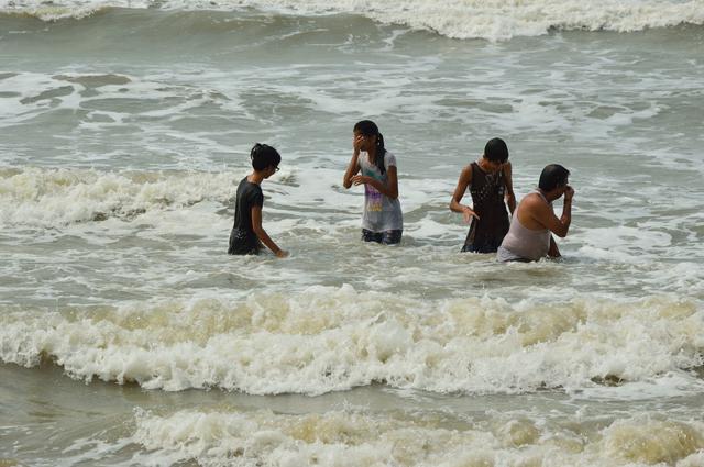Playful people with sea waves. May 2015.