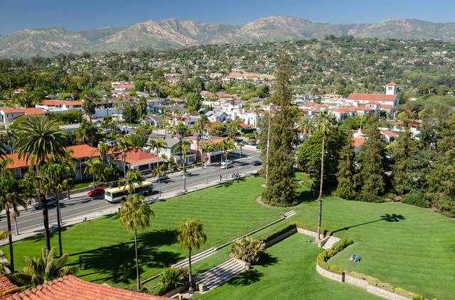 View north from the tower of the Santa Barbara Courthouse, showing red tile-roofed mission-style buildings and the mountains beyond