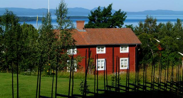 A typical Falu red-colored cabin, with a view of Lake Siljan.