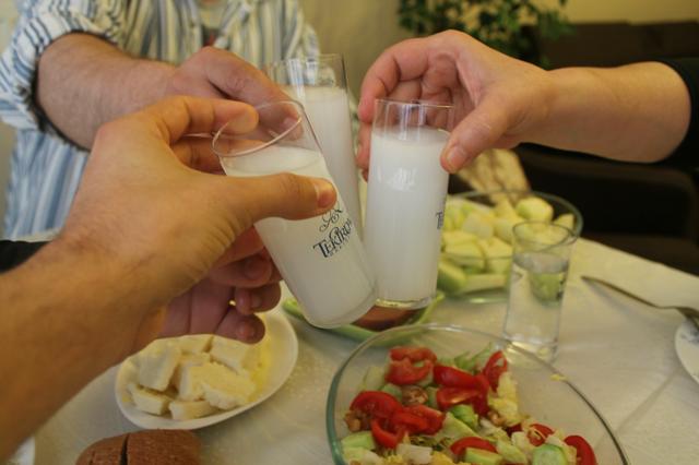 Three members of a Turkish family toast with rakı during a meal