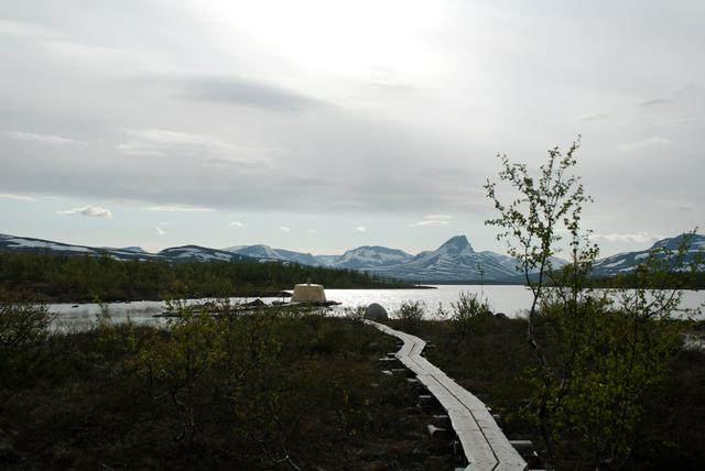 The tripoint in June, with high mountains in the background.