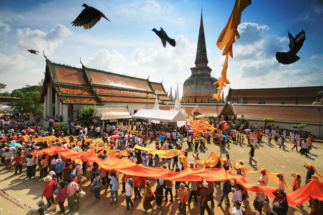 A procession of Buddhists bearing a long cloth during Hae Pha Khuen That Festival at Wat Phra Maha That Woramahawihan, in Nakhon Si Thammarat Province