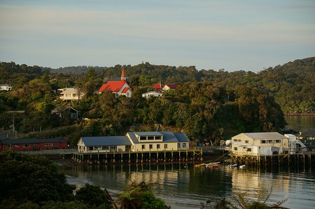 Oban Wharf, Visitor Centre (dark red) and church (light red) in the setting sun