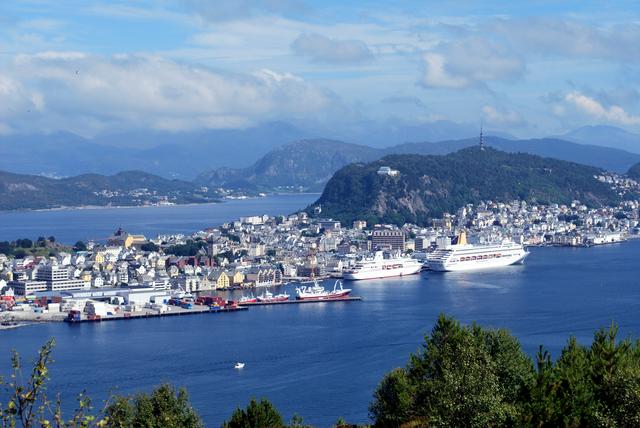 Mt Aksla viewpoint on the steep cliff above cruise ships docking at the city centre